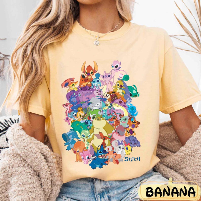 K&ouml;nnte beinhalten: Ein gelbes T-Shirt mit einem bunten Grafikdruck von Stitch und seinen Freunden aus dem Disney-Film Lilo & Stitch. Der Text "Stitch" ist unten auf dem Druck aufgedruckt.
