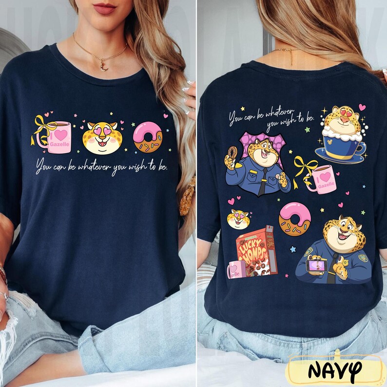 May include: Navy blue t-shirt with a whimsical design. The front features a coffee mug, a cheetah, and a donut, with the text "You can be whatever you wish to be." The back shows the same cheetah in different scenarios.