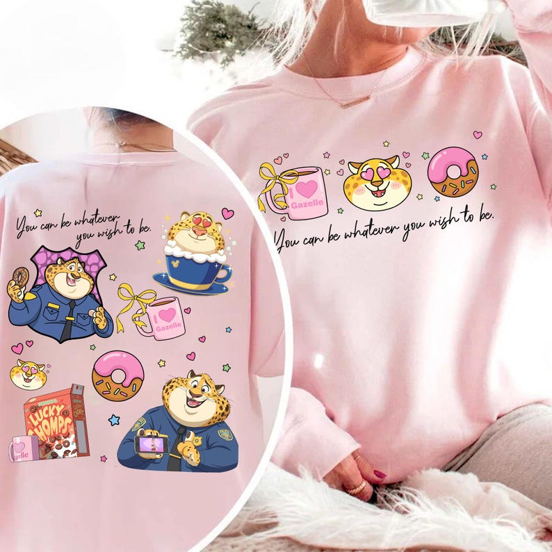May include: Pink sweatshirt with a cartoon leopard design and the text "You can be whatever you wish to be." The design includes a coffee cup, a donut, and a box of Lucky Homps cereal. The leopard is wearing a police uniform.