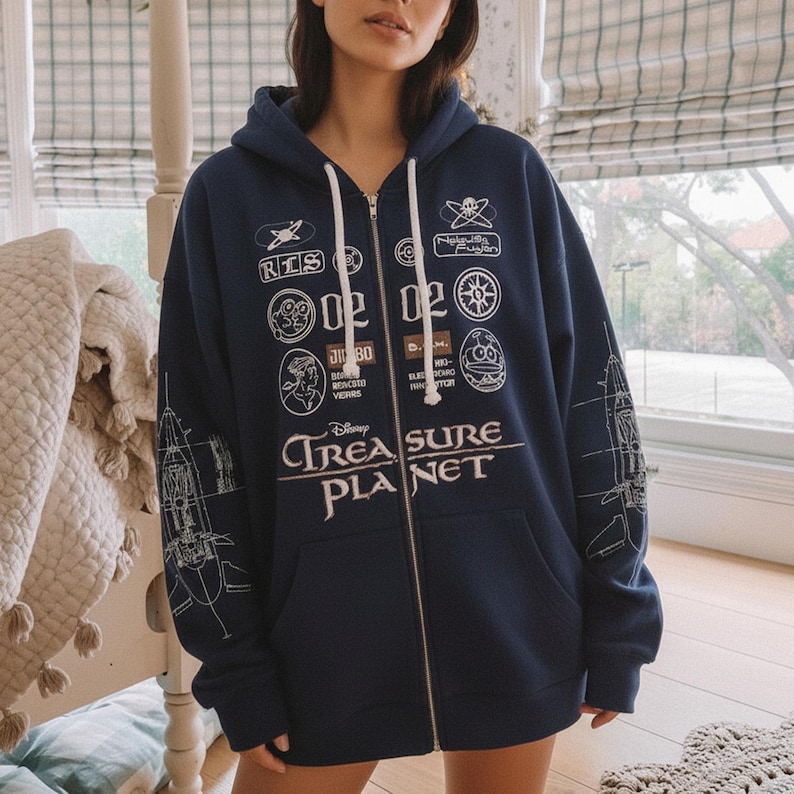 May include: Navy blue zip-up hoodie with white drawstring and multiple white graphic patches. The hoodie features the text "Disney TREASURE PLANET" in white, with a spaceship design on the sleeves.