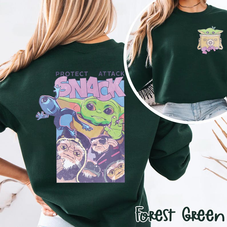 May include: Forest green sweatshirt featuring a graphic of a green alien character with the text "PROTECT ATTACK SNACK". The design includes other alien characters. A smaller graphic of the alien character is on the upper right chest.