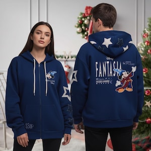 Puede incluir: Sudadera con capucha azul marino con cremallera y diseño de Mickey Mouse Fantasia. La sudadera tiene cordones blancos, detalles de estrellas en las mangas y la palabra "Fantasia" impresa en la espalda. También es visible el logotipo de Disney.