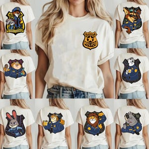 May include: Cream-coloured t-shirts with various Zootopia police character designs. One shirt's front displays a Zootropolis Police badge. The backs of the shirts showcase cartoon characters like a fox, bunny, and tiger in police uniforms.