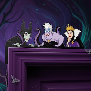 May include: Decorative wooden figures of Disney villains Maleficent, Ursula, and the Evil Queen. The figures are black, purple, and white, with details like Maleficent's horns, Ursula's tentacles, and the Evil Queen's crown. The figures are placed on a purple door frame.
