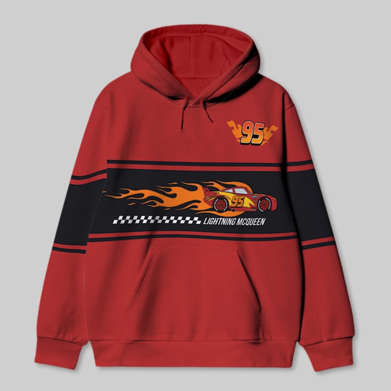 以下が含まれることがあります： 胸に黒と黄色のストライプが入った赤いフード付きスウェットシャツ。ストライプには、炎がついた赤いレーシングカーの漫画の画像と、「ライトニング・マックィーン」というテキストと「95」という数字が描かれています。