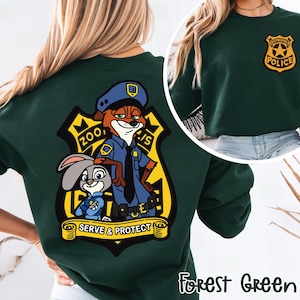 May include: Forest green sweatshirt with a Zootropolis police badge on the front and a large graphic on the back. The back graphic features Nick Wilde and Judy Hopps in police uniforms, with the words "Zootropolis Police" and "Serve & Protect".