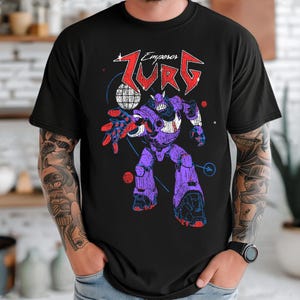 Puede incluir: Camiseta negra con un gr&aacute;fico de un robot morado y el texto "Zurg Emperors" en rojo y blanco. El dise&ntilde;o del robot incluye detalles rojos y azules, sobre un fondo de formas geom&eacute;tricas.