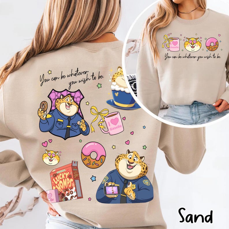 May include: Sand-colored sweatshirt featuring a cartoon cheetah character in a police uniform, holding a donut and a phone. The design includes a pink donut, a coffee cup, and the text "You can be whatever you wish to be."