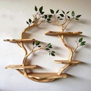 May include: A unique, wooden wall shelf with a tree-like design. The shelf features multiple tiers of natural wood platforms supported by branches, adorned with green leaves. The shelf is designed to be mounted on a wall.