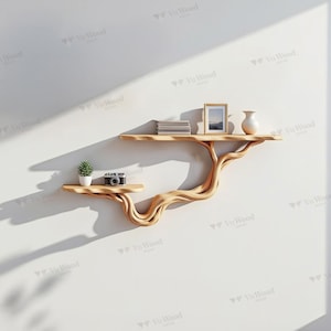 May include: A unique, light-colored wooden wall shelf with a tree-like design. The shelf has two tiers and is holding a small potted plant, a vintage camera, a stack of books, a framed picture, and a vase. The shelf is mounted on a white wall.