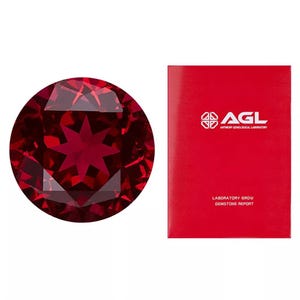 May include: A deep red, round, faceted gemstone with a star-shaped pattern in the centre. The gemstone is accompanied by a red card with the text "AGL Antwerp Gemological Laboratory" and "Laboratory Grown Gemstone Report".