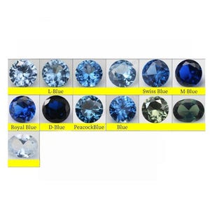 May include: A collection of thirteen faceted gemstones arranged in a grid, displaying various shades of blue and green. The stones are labeled with text including Swiss Blue, M-Blue, Royal Blue, D-Blue, PeacockBlue, and Blue, showcasing different hues.