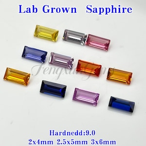 May include: A collection of lab-grown sapphire gemstones in various colors, including yellow, gray, pink, purple, orange, and blue. The rectangular-cut stones are displayed on a light background. Text at the top reads "Lab Grown Sapphire".