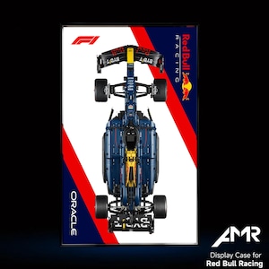 May include: A blue and yellow Lego model of a Formula 1 race car with the Red Bull Racing logo and Oracle branding. The car is on a white background with red and blue stripes.