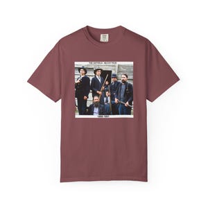 May include: A maroon t-shirt featuring a graphic of a group of men in period clothing, with the text "THE HATFIELD - MCCOY FEUD" and "1865-1891". The image is a vintage-style photograph.