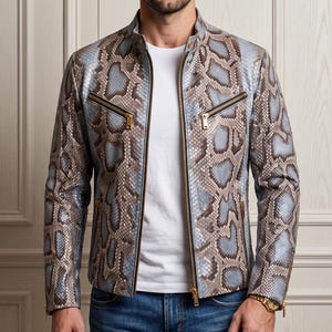 May include: A jacket featuring a snakeskin pattern in shades of light blue, grey, and brown. The garment has a stand-up collar, a central front zipper, two zippered chest pockets, and two lower zippered pockets. The sleeves have zippered cuffs.