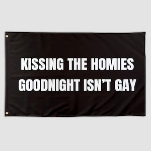 Può includere: Bandiera nera con testo bianco: "KISSING THE HOMIES GOODNIGHT ISN'T GAY". La bandiera ha occhielli agli angoli per appenderla. Il testo è in grassetto, carattere sans-serif.