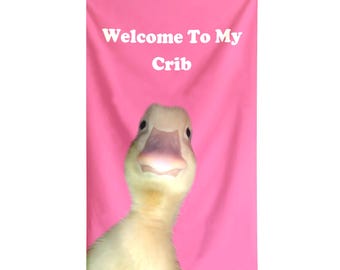 May include: A pink banner with the text "Welcome To My Crib" in white. A close-up of a yellow duckling with a pink beak is centered below the text.