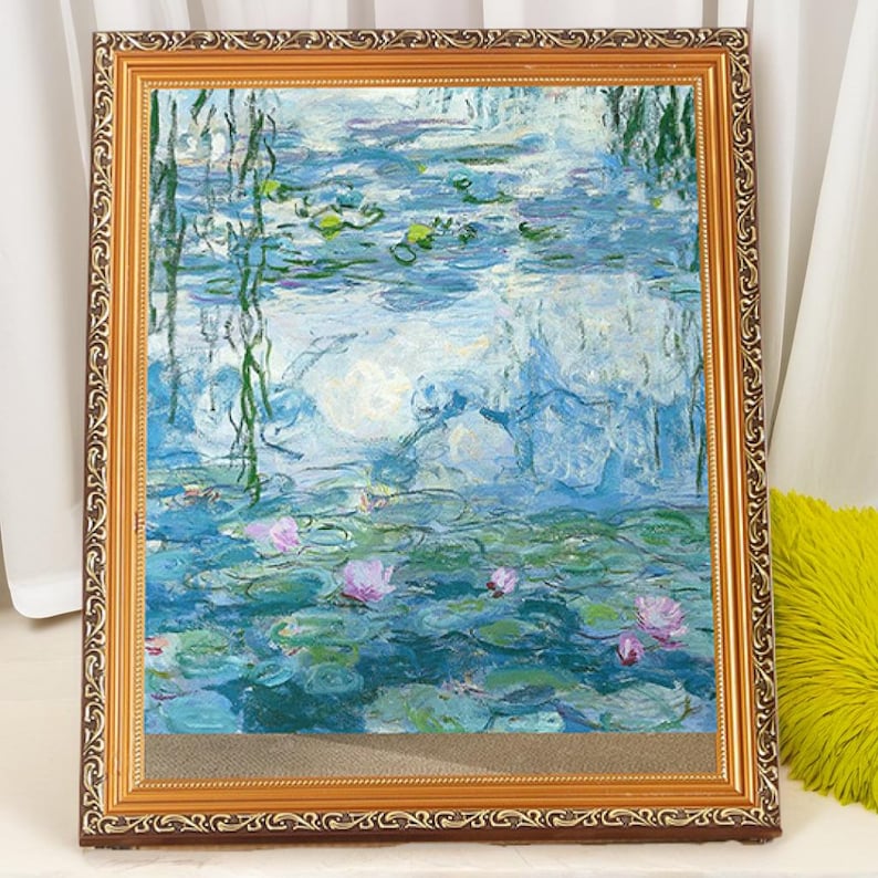 May include: A framed painting of a water lily pond with blue and green water, white clouds, and pink water lilies. The frame is gold with a decorative border.