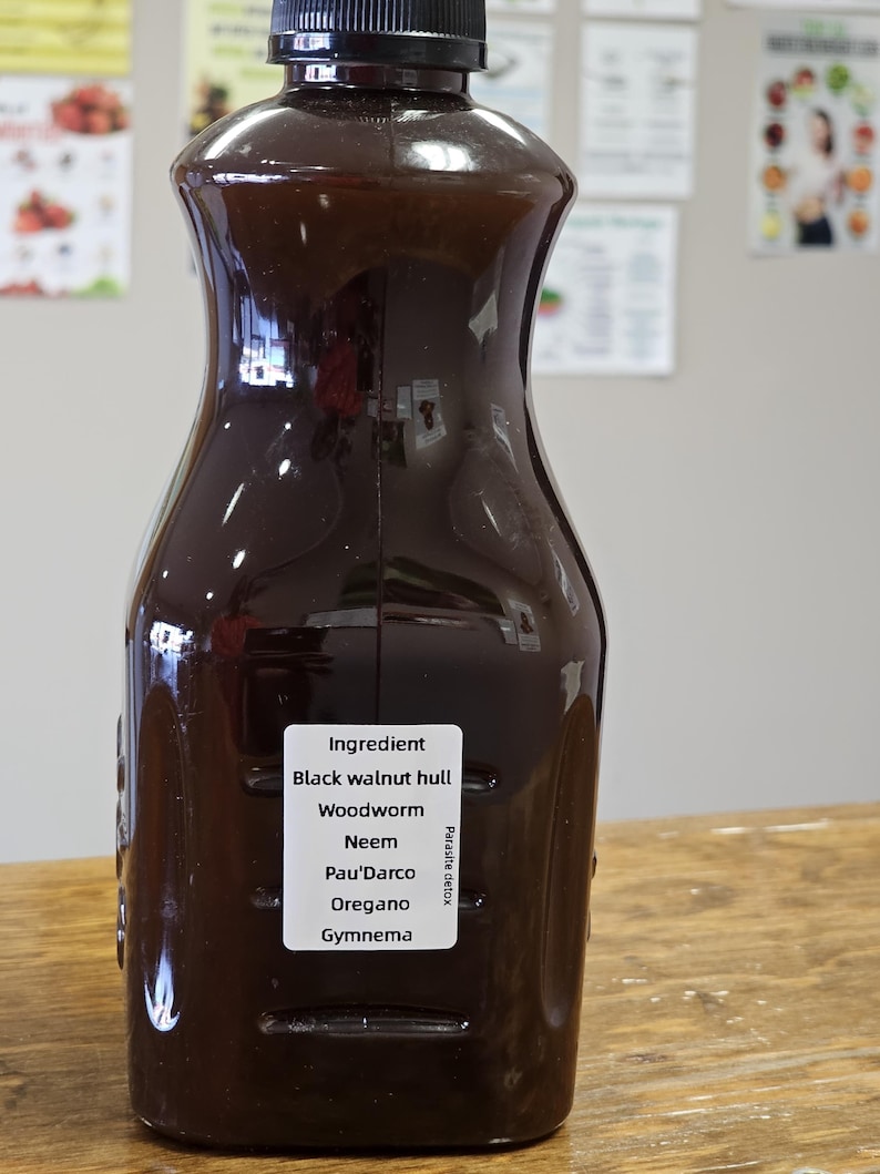 May include: A dark brown glass bottle with a black cap, labeled "Ingredient: Black walnut hull, Woodworm, Neem, Pau'dArco, Oregano, Gymnema.  Parasite detox."