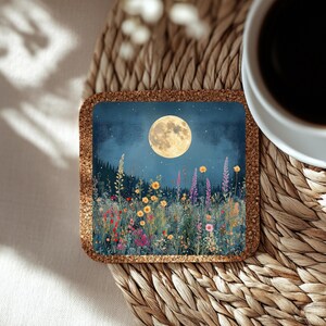 May include: Square cork coaster featuring a nighttime meadow scene with a full moon and colorful wildflowers. The coaster has a dark blue background with a forest silhouette and a starry sky. The coaster is surrounded by a brown cork border.