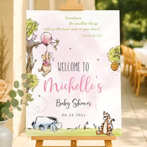 Editable baby shower welcome sign for a girl with pink text and soft watercolor illustrations of Winnie the Pooh holding a pink balloon, Piglet in a tree, Eeyore, and Tigger; printable sign displayed outdoors on a wooden easel.
