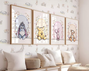 May include: Four framed prints featuring Winnie the Pooh and his friends. Each print has a floral border and a light pink, blue, or yellow background. The prints are hung on a white wall with a light brown wood trim.