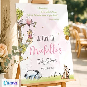 May include: A pink and white welcome sign with Winnie the Pooh characters. The sign says "Welcome to Michelle's Baby Shower 06.24.20xx". The quote "Sometimes the smallest things take up the most room in your heart." - Winnie the Pooh is at the top of the sign.