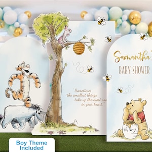 Classic Winnie the Pooh baby shower backdrop set in a soft blue boy theme. Includes personalized name panel, character cutouts of Tigger and Eeyore, and Piglet on a tree with honey bees and the phrase 'Sometimes the smallest things take up the most room in your heart.' Ideal for a customized baby boy shower decoration.