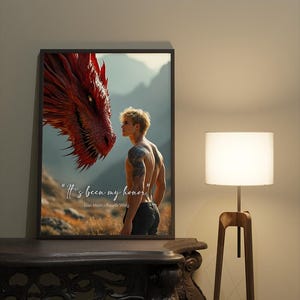 May include: A black framed poster with a red dragon and a man looking at each other. The text on the poster reads "It's been my honor" Lian Mori - Fourth Wing.