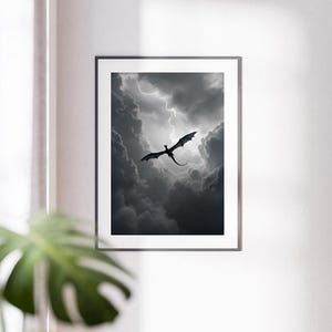 Op de afbeelding: Een zwart silhouet van een draak die door een stormachtige lucht vliegt met donkere wolken en bliksem.
