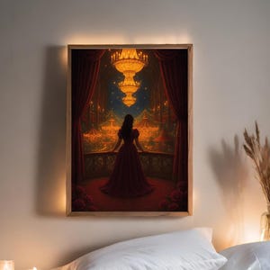May include: A framed art print showing a woman in a red dress looking out at a night-time carnival. The artwork features a large chandelier, red curtains, and a balcony with roses. The print is set in a wooden frame with a warm, glowing light.