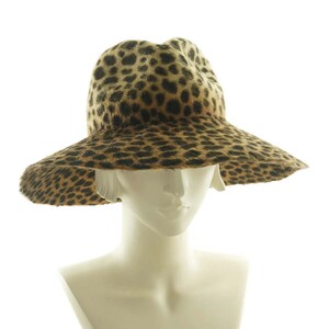 May include: A wide-brimmed hat with a leopard print pattern. The hat is made of a soft, furry material and has a wide, floppy brim.