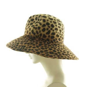 May include: A wide-brimmed hat with a leopard print pattern. The hat is made of a soft, furry material and has a wide, floppy brim.