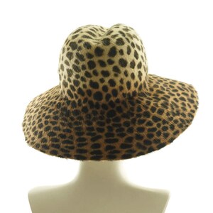 May include: A wide-brimmed hat with a leopard print pattern. The hat is made of a soft, furry material and has a wide, floppy brim.