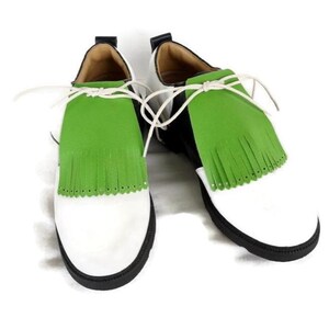 Lime green apple golf shoe kilties on a pair of mens black and white saddle style golf shoes with white shoe laces and black soles. Kilties have 15 fringes each with a single perforation in the point. Front view. Solid white background.