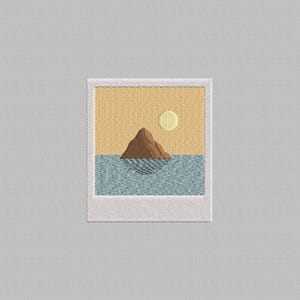 May include: Embroidered patch featuring a landscape scene within a polaroid frame. The design includes a brown mountain, blue water, a yellow sun, and a yellow and orange sky. The patch is bordered by a white frame.
