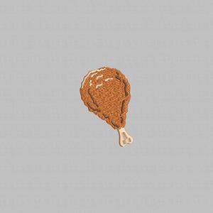 Peut inclure: Un écusson brodé représentant une cuisse de poulet frite. Le patch est principalement marron avec des accents marron clair et blancs, représentant la peau croustillante et l'os du poulet. Le fond est gris uni.