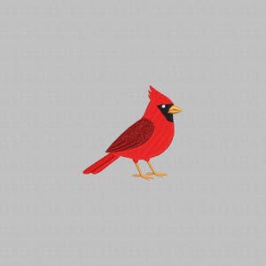 May include: Embroidered image of a vibrant red cardinal bird with a black mask and a yellow beak. The bird is standing on two thin yellow legs against a gray background. The bird's feathers are detailed with textured embroidery.