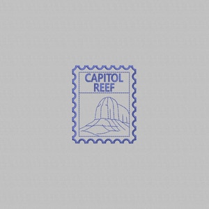 May include: A blue embroidered design on a light grey fabric background. The embroidery features a postage stamp shape with a scalloped border, containing the text CAPITOL REEF above a line drawing of a rock formation with layered contours.