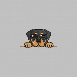 May include: Embroidered patch featuring a Rottweiler dog wearing sunglasses. The dog has black fur with tan markings and is peeking over a brown bar. The patch is on a gray background.