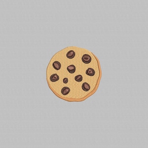 Puede incluir: Una galleta bordada redonda con una base marrón claro y chispas de chocolate marrón oscuro. La galleta tiene una apariencia texturizada y un borde ligeramente más oscuro. El diseño está centrado en un fondo gris claro.