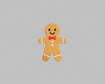 Peut inclure: Un bonhomme en pain d'épices avec un visage souriant, un nœud papillon rouge et des détails en glaçage blanc. Le bonhomme en pain d'épices est de couleur brun clair et a deux boutons blancs. Le fond est gris clair uni.