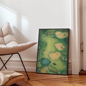 May include: A framed golf course art print. The artwork shows a detailed overhead view of a golf course with green fairways, sand traps, and a water hazard. Numerous figures of people are scattered throughout the course, with a golf cart visible.