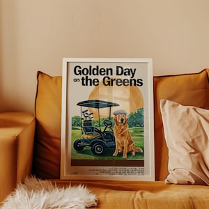 May include: A white framed poster with the text "Golden Day on the Greens" in black. The poster features a cartoon illustration of a golden retriever wearing a cap and riding in a golf cart on a green golf course.
