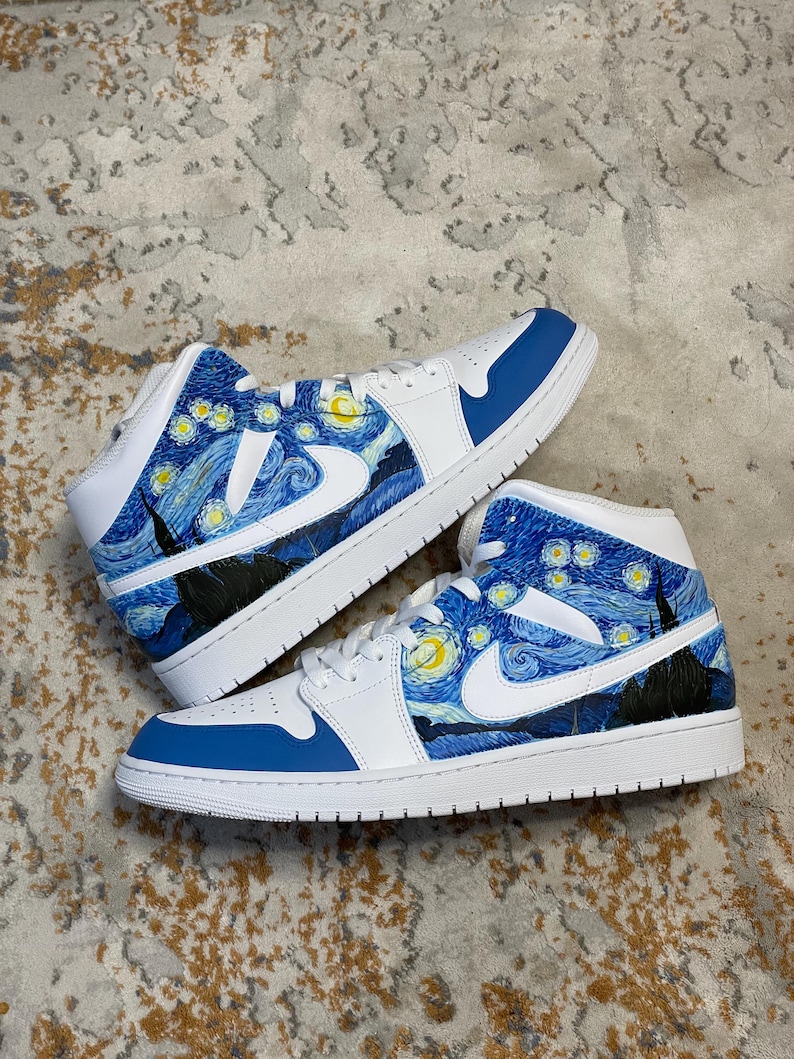 May include: Pair of white and blue sneakers with a custom design inspired by Van Gogh's "Starry Night" painting. The shoes feature a blue and white color scheme, with the iconic artwork covering the sides and heel.