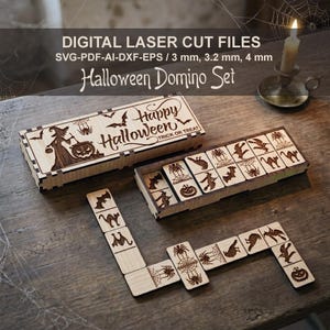 May include: A wooden Halloween domino set with laser-cut designs. The set includes a box with "Happy Halloween" text and dominoes featuring bats, spiders, and witch silhouettes. The dominoes are arranged on a wooden surface.