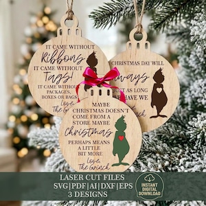 Peut inclure: Trois ornements ronds en bois avec du texte découpé au laser et des silhouettes de personnages. Le texte indique : It came without ribbons, it came without tags, it came without packages, boxes or bags, Christmas day will always be just as long as we have we, maybe Christmas doesn't come from a store, maybe Christmas perhaps means a little bit more, love, the Grinch. Un ruban rose vif est noué sur l'ornement central.