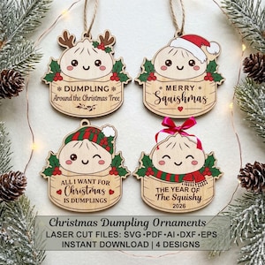 May include: Four wooden Christmas ornaments shaped like dumplings in bamboo steamers. Each features a cute face, holly leaves, and text: DUMPLING Around the Christmas Tree, MERRY Squishmas, ALL I WANT FOR Christmas IS DUMPLINGS, and THE YEAR OF The Squishy 2026.