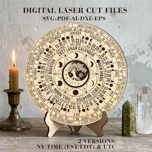 May include: A circular wooden 2027 lunar calendar featuring laser-cut text and graphics, including months, zodiac signs, moon phases, and a central tree design. The text reads DIGITAL LASER CUT FILES SVG-PDF-AI-DXF-EPS and 2 VERSIONS: NY TIME (EST/EDT) & UTC.